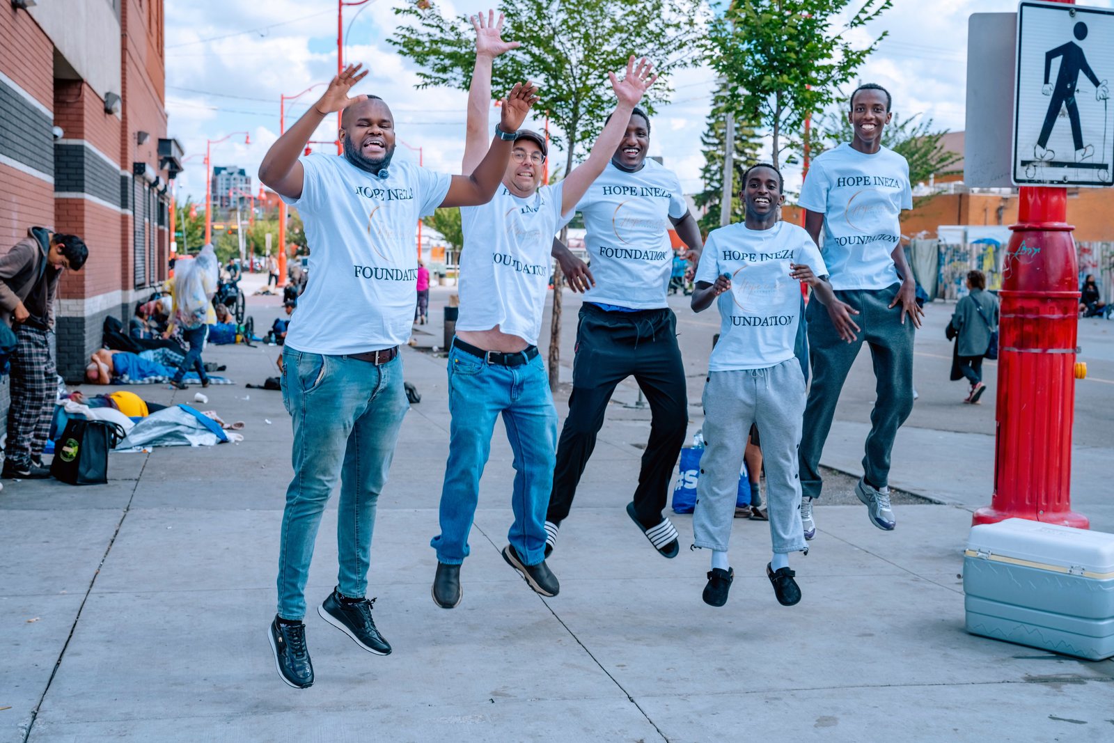 The Hope Ineza Foundation outreach team jumping together on the street at the end of a round
