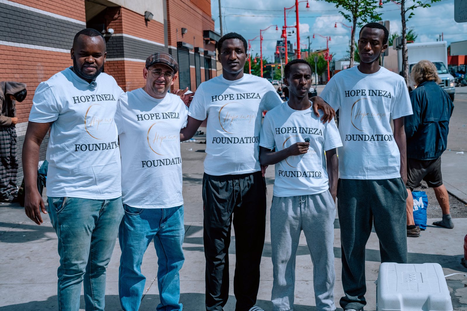 The Hope Ineza Foundation volunteer team standing together in branded shirts on a city street