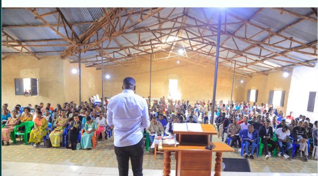 A large hall in a Ugandan refugee settlement filled with people attending a Hope Ineza Foundation session