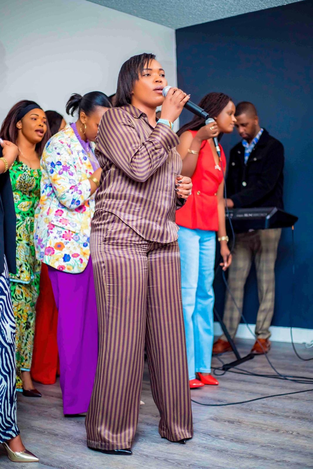 A woman singing into a microphone at a community event