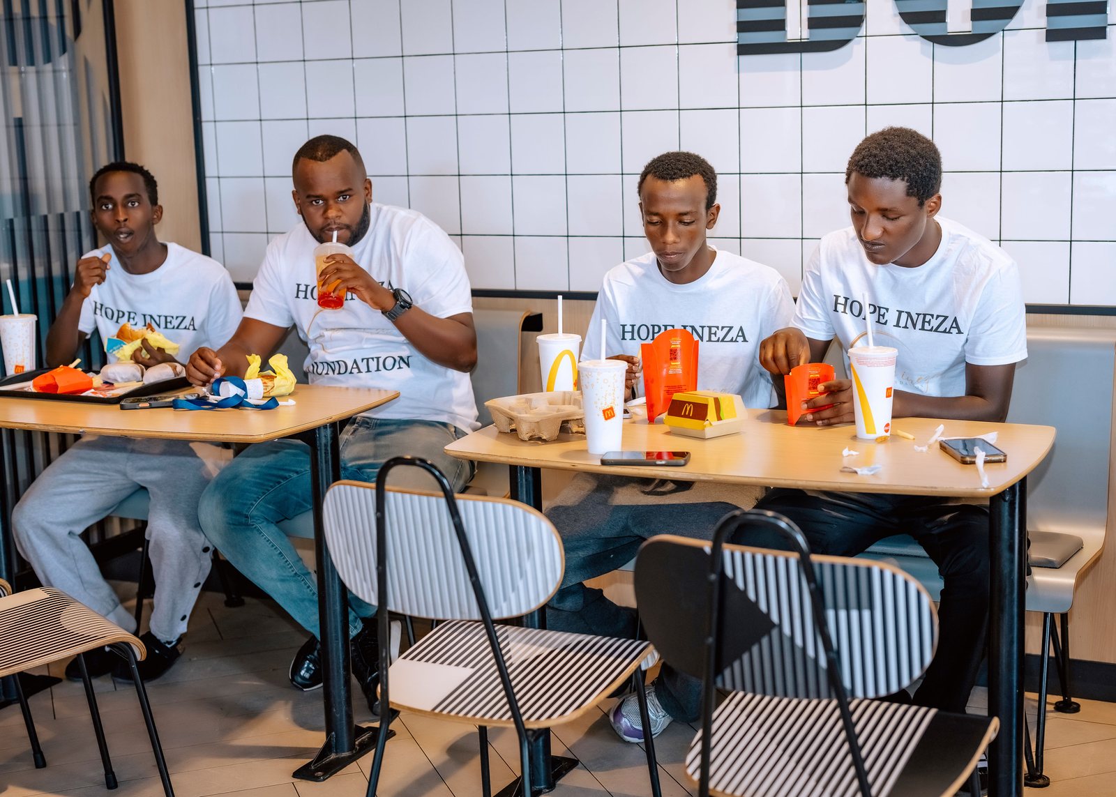 Hope Ineza Foundation volunteers seated together around a table sharing a meal