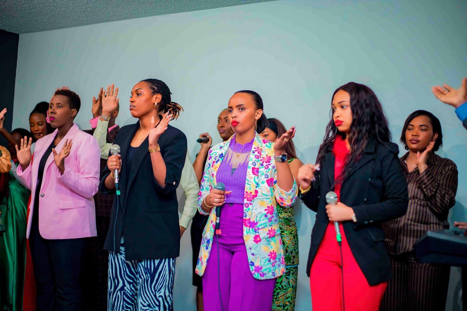 A group of women singing together with microphones at a community gathering